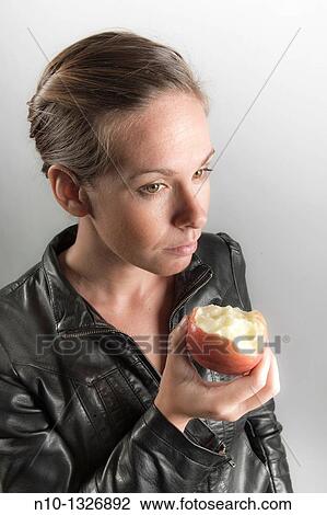 Young woman eating an apple View Large Photo Image Stock Image - Young woman eating an apple. Fotosearch