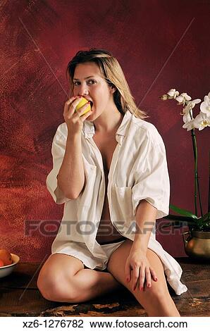 Stock Image - Young woman eating an apple. Fotosearch