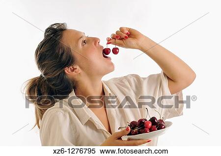 Young woman eating cherries View Large Photo Image Stock Photography - Young woman eating cherries. Fotosearch