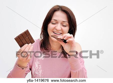Young woman eating chocolate View Large Photo Image Stock Photograph - Young woman eating chocolate. Fotosearch