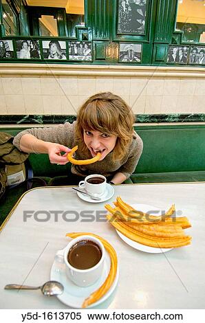 young woman eating churros with hot chocolate in San-Gines Chocolateria, Madrid, Spain, Europe View Large Photo Image Stock Photography - young woman eating churros with hot chocolate in San-Gines Chocolateria, Madrid, Spain, Europe. Fotosearch