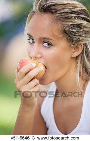 Young woman eating fruit. View Large Photo Image Stock Image - Young woman eating fruit.. Fotosearch