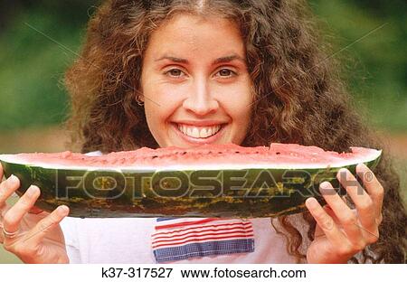 Stock Photo - Young woman eating water melon. Fotosearch