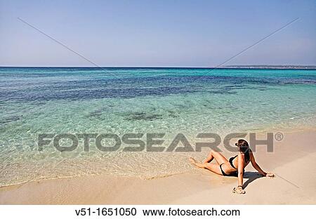 Stock Image - Young woman enjoying a day at the beach in Formentera, Balearic Island. Fotosearch