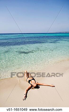 Stock Photo - Young woman enjoying a day at the beach in Formentera, Spain. Fotosearch