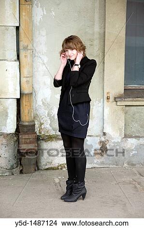 young woman enjoying listening music, public place, train station, Lodz, Poland, MP3 View Large Photo Image Picture - young woman enjoying listening music, public place, train station, Lodz, Poland, MP3. Fotosearch
