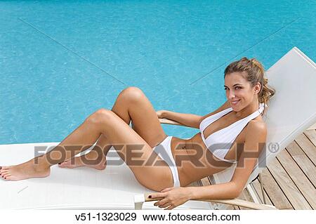 Young woman enjoying sun in hammock by the pool View Large Photo Image Stock Photo - Young woman enjoying sun in hammock by the pool. Fotosearch
