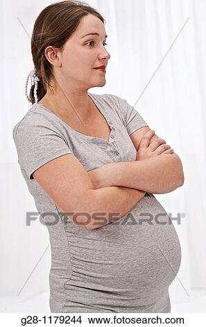 Young woman expecting a baby in grey View Large Photo Image Picture - Young woman expecting a baby in grey. Fotosearch