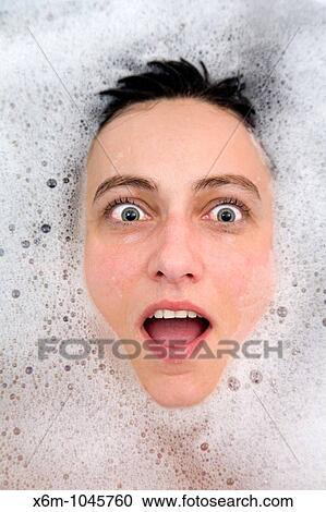 Stock Image - young woman face having a bath. Fotosearch