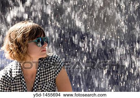 young woman face in sunglasses, falling water in the background View Large Photo Image Picture - young woman face in sunglasses, falling water in the background. Fotosearch