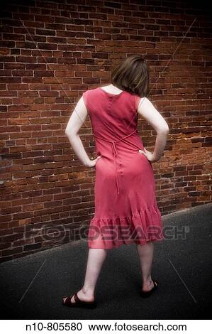 Young woman facing a brick wall. View Large Photo Image Stock Image - Young woman facing a brick wall.. Fotosearch