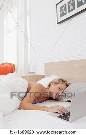 Young woman fallen asleep while on her laptop View Large Photo Image Stock Image - Young woman fallen asleep while on her laptop. Fotosearch