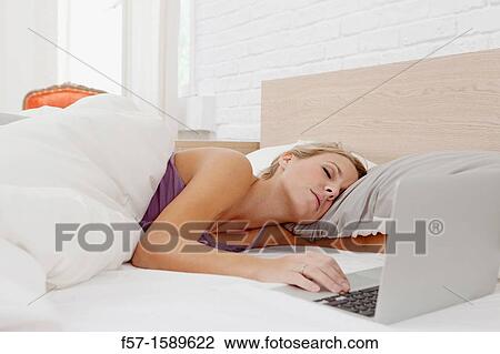 Young woman fallen asleep while on her laptop View Large Photo Image Stock Image - Young woman fallen asleep while on her laptop. Fotosearch