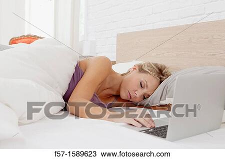 Young woman fallen asleep while on her laptop View Large Photo Image Stock Image - Young woman fallen asleep while on her laptop. Fotosearch