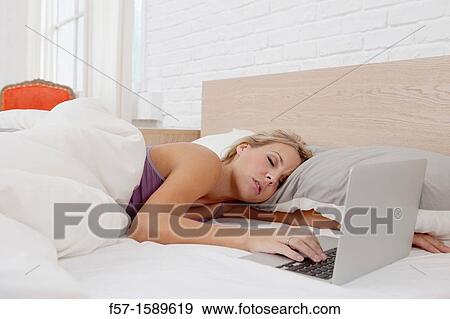 Young woman fallen asleep while on her laptop View Large Photo Image Stock Photo - Young woman fallen asleep while on her laptop. Fotosearch
