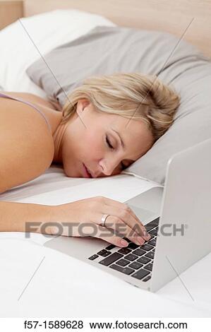 Young woman fallen asleep while on her laptop View Large Photo Image Stock Photo - Young woman fallen asleep while on her laptop. Fotosearch