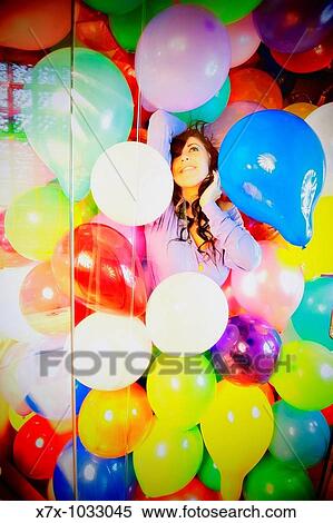 Young woman fantasizes in a shower filled with colorful balloons View Large Photo Image Stock Photography - Young woman fantasizes in a shower filled with colorful balloons. Fotosearch