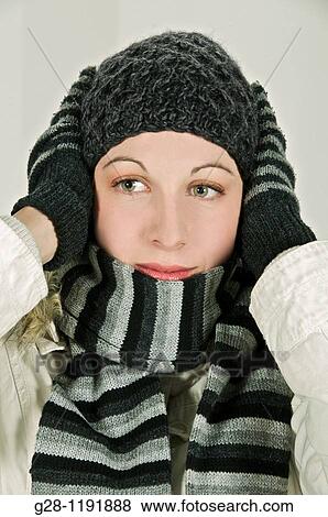 Young woman feeling cold and holding her head in a woolen hat, and her woolen gloved hands View Large Photo Image Stock Photo - Young woman feeling cold and holding her head in a woolen hat, and her woolen gloved hands. Fotosearch