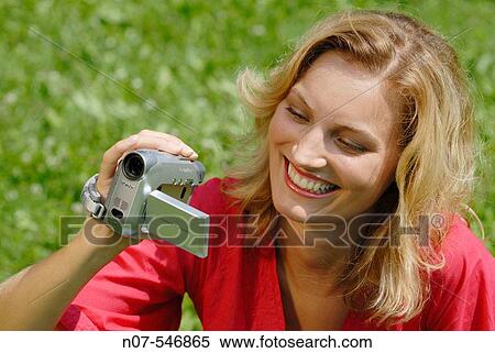 Young woman filming with a digital camcorder View Large Photo Image Stock Photography - Young woman filming with a digital camcorder. Fotosearch