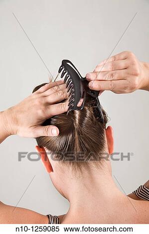Stock Photography - Young woman fixing her hair. Fotosearch