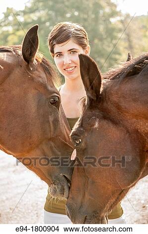 Young woman framed by two horses View Large Photo Image Picture - Young woman framed by two horses. Fotosearch