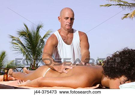 Stock Image - Young woman getting a massage outdoor in a spa. Fotosearch