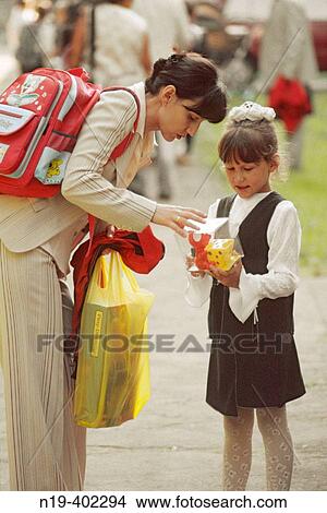 Young woman gives a gift to a girl. View Large Photo Image Picture - Young woman gives a gift to a girl.. Fotosearch