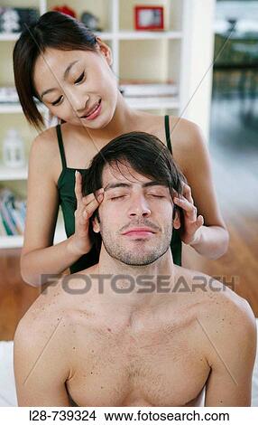 Young woman giving a young man a head massage View Large Photo Image Picture - Young woman giving a young man a head massage. Fotosearch