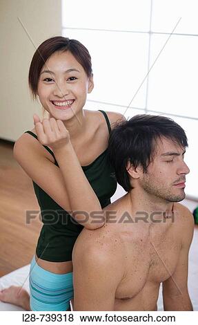 Young woman giving a young man a shoulder massage View Large Photo Image Stock Photo - Young woman giving a young man a shoulder massage. Fotosearch