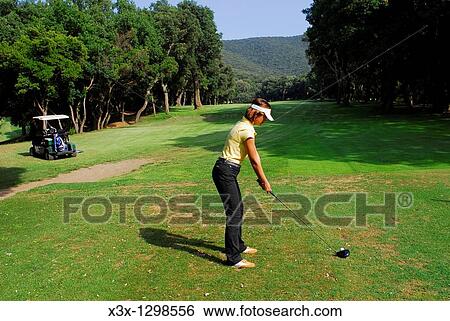Young woman golfer preparing for a driving shot View Large Photo Image Stock Photograph - Young woman golfer preparing for a driving shot. Fotosearch
