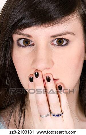 Stock Image - Young woman hand covering mouth.. Fotosearch
