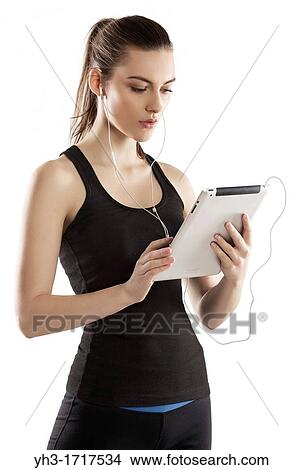 Young woman handholding a digital tablet tracking her exercise View Large Photo Image Picture - Young woman handholding a digital tablet tracking her exercise. Fotosearch