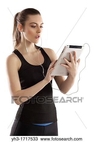 Young woman handholding a digital tablet tracking her exercise View Large Photo Image Stock Image - Young woman handholding a digital tablet tracking her exercise. Fotosearch