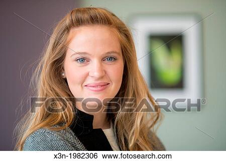 Young woman hanging photographs on wall. View Large Photo Image Stock Photograph - Young woman hanging photographs on wall.. Fotosearch