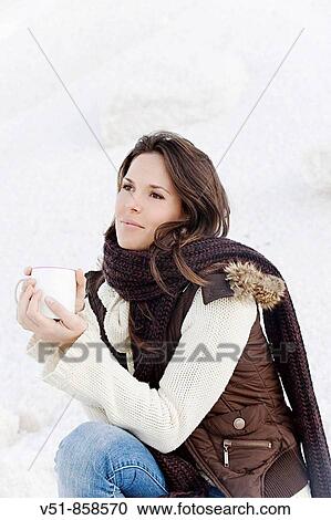 Young woman having a drink in winter outdoor View Large Photo Image Stock Image - Young woman having a drink in winter outdoor. Fotosearch