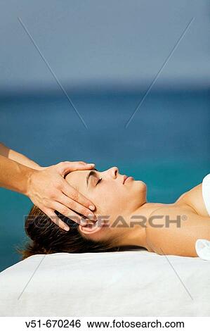 Young woman having a head massage by the sea View Large Photo Image Stock Photograph - Young woman having a head massage by the sea. Fotosearch