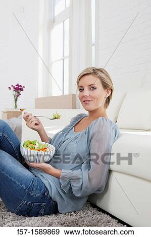 Stock Photo - Young woman having a salad for lunch. Fotosearch