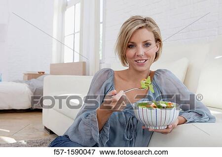 Stock Photo - Young woman having a salad for lunch. Fotosearch