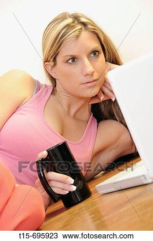 Young woman having coffee working on computer View Large Photo Image Stock Image - Young woman having coffee working on computer. Fotosearch
