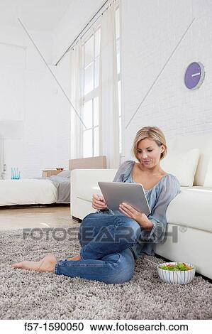 Young woman having lunch while socializing on her tablet computer View Large Photo Image Stock Image - Young woman having lunch while socializing on her tablet computer. Fotosearch