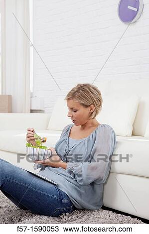Young woman having lunch while socializing on her tablet computer View Large Photo Image Stock Image - Young woman having lunch while socializing on her tablet computer. Fotosearch