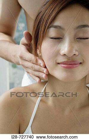 Young woman having temples massaged by man, close-up View Large Photo Image Stock Image - Young woman having temples massaged by man, close-up. Fotosearch