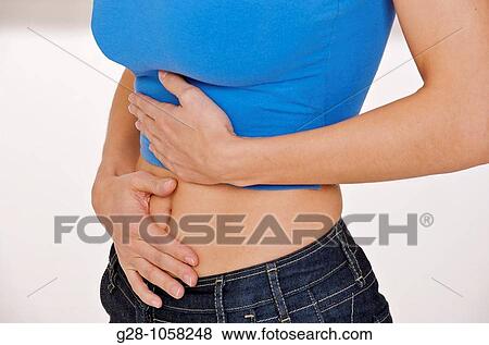 young woman (head invisible) holding her stomach with her hands and suffering from periods or stomach pains View Large Photo Image Stock Photo - young woman (head invisible) holding her stomach with her hands and suffering from periods or stomach pains. Fotosearch