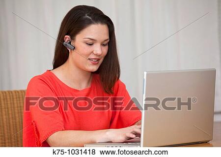 Stock Photo - young woman headphone and laptop. Fotosearch