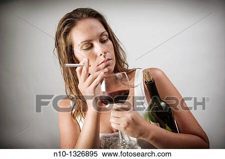 Young woman holding a bottle and glass of wine, and a cigarette View Large Photo Image Stock Photography - Young woman holding a bottle and glass of wine, and a cigarette. Fotosearch