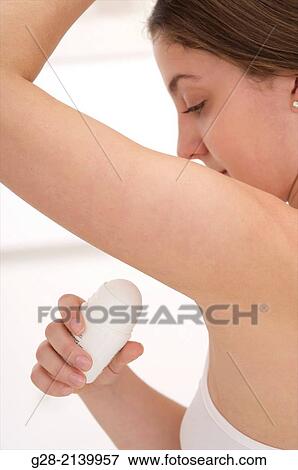 young woman holding a deodorant stick under her arm in her bathroom View Large Photo Image Stock Photo - young woman holding a deodorant stick under her arm in her bathroom. Fotosearch