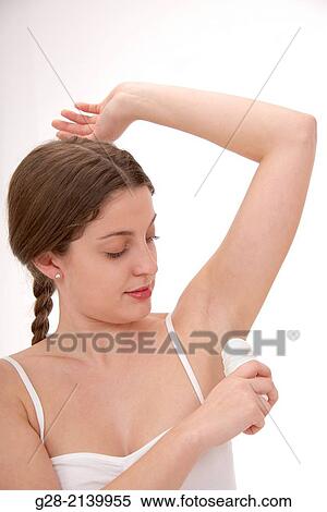 young woman holding a deodorant stick under her arm in her bathroom View Large Photo Image Stock Photography - young woman holding a deodorant stick under her arm in her bathroom. Fotosearch