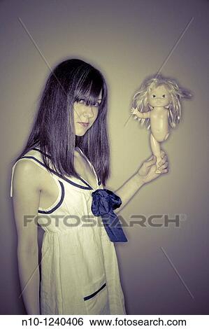 Young woman holding a doll that is missing an arm and leg View Large Photo Image Stock Photograph - Young woman holding a doll that is missing an arm and leg. Fotosearch