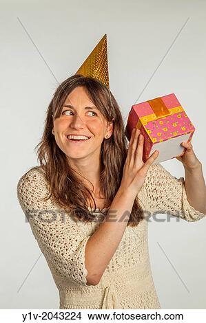 Picture - Young woman holding a gift box.. Fotosearch