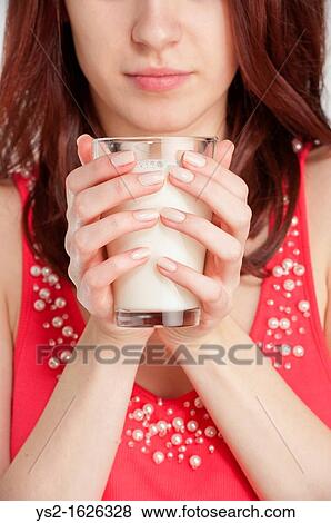 Young woman holding a glass of milk View Large Photo Image Stock Photo - Young woman holding a glass of milk. Fotosearch